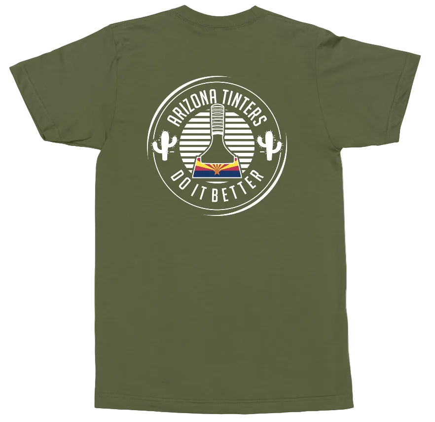 An olive green short-sleeve t-shirt shown flat against a white background, featuring a circular graphic on the chest with a guitar, cacti, and the text 'ARIZONA TINTERS DO IT BETTER'.