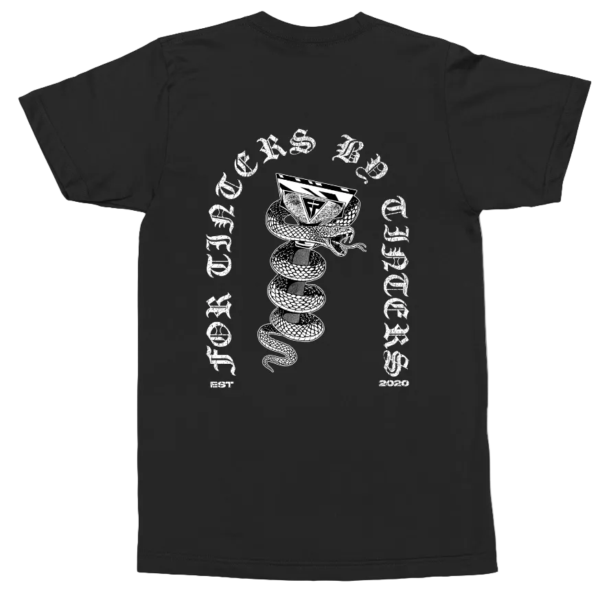 A black short-sleeve t-shirt shown from the back, featuring a large white graphic print of a coiled snake with a knife in its mouth, surrounded by gothic text reading 'FOR THINGS BY STAINED' and 'EST. 2050'.