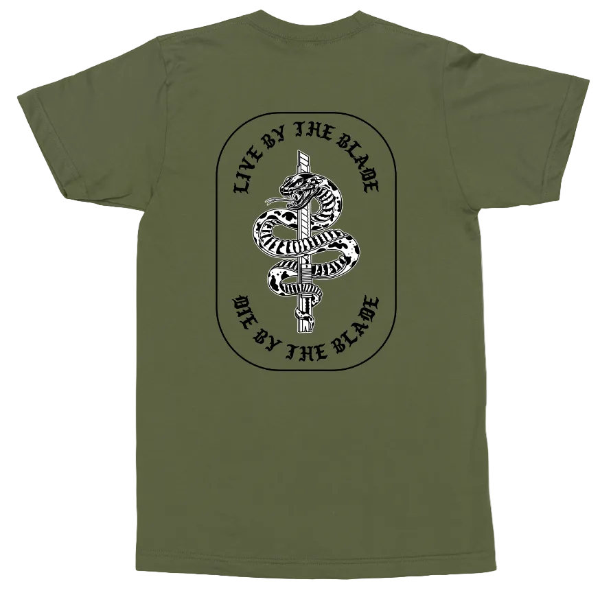 An olive green short-sleeve t-shirt shown flat against a white background, featuring a black and white graphic of a coiled snake wrapped around a sword, with the text 'LIVE BY THE BLADE' arched above and 'DIE BY THE BLADE' below.