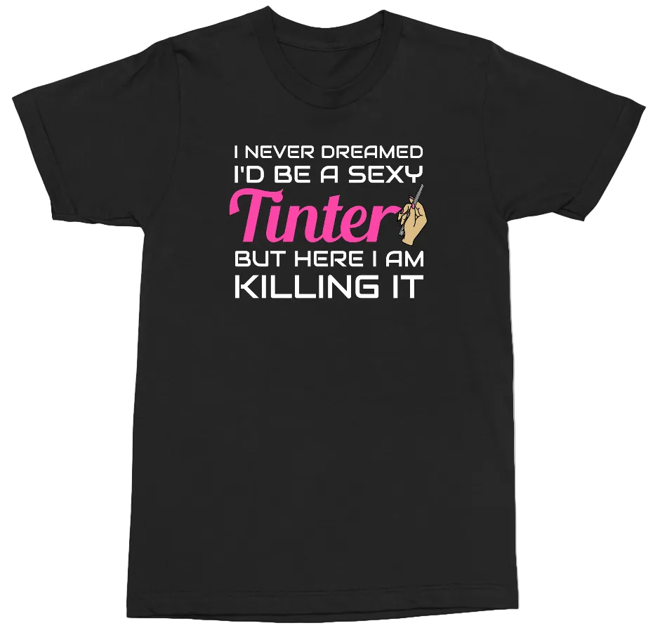 A black short-sleeve crewneck t-shirt with a graphic text print on the front. The text reads 'I NEVER DREAMED I'D BE A SEXY Tinter BUT HERE I AM KILLING IT' in white and pink lettering, with a small hand holding a paintbrush graphic replacing the letter 'i' in 'Tinter'.