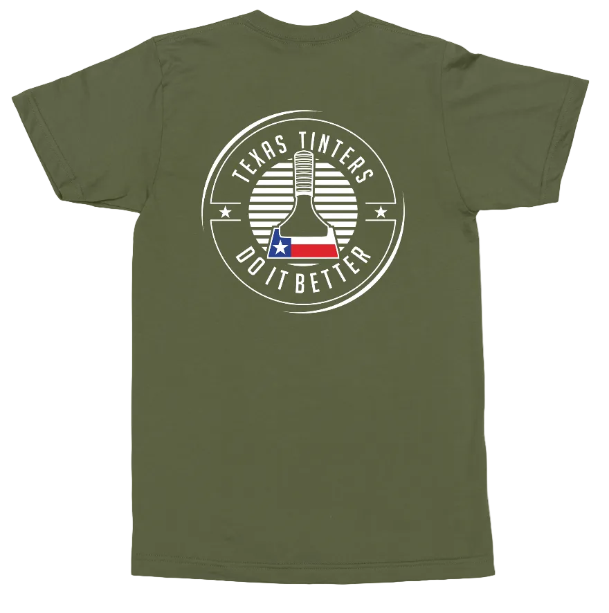 An olive green short-sleeve t-shirt shown flat against a white background, featuring a circular graphic on the back with a wine bottle, stars, and the text 'TEXAS TINTERS DO IT BETTER' with a Texas flag detail.