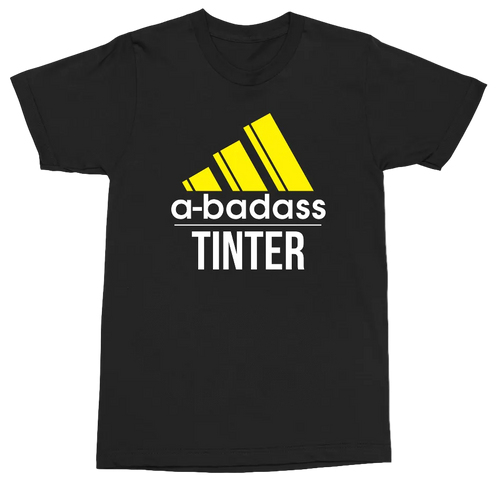 A black short-sleeve t-shirt with a graphic print featuring a yellow Adidas-style logo, the text 'a-badass' in white, and 'TINTER' in white below it, shown on a plain white background.