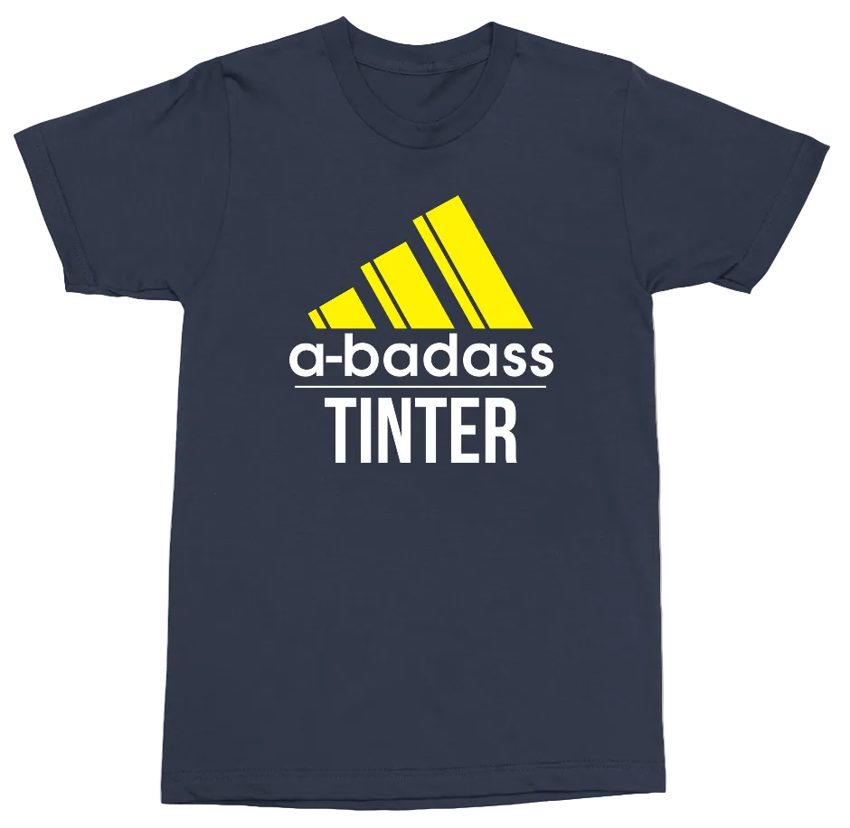 A navy blue short-sleeve t-shirt with a yellow and white graphic on the front. The graphic features a yellow logo resembling the Adidas logo, with the text 'a-badass' in yellow and 'TINTER' in white underneath.
