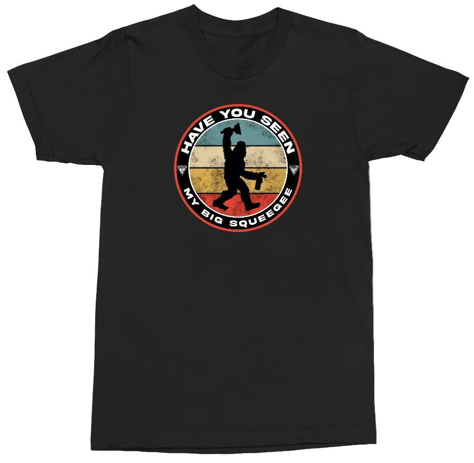 A black short-sleeve crewneck t-shirt featuring a circular retro-style graphic on the chest. The graphic shows a silhouette of a person carrying a large water bottle, with the text 'HAVE YOU SEEN MY BIG SQUEEGER' in white lettering around the circle.