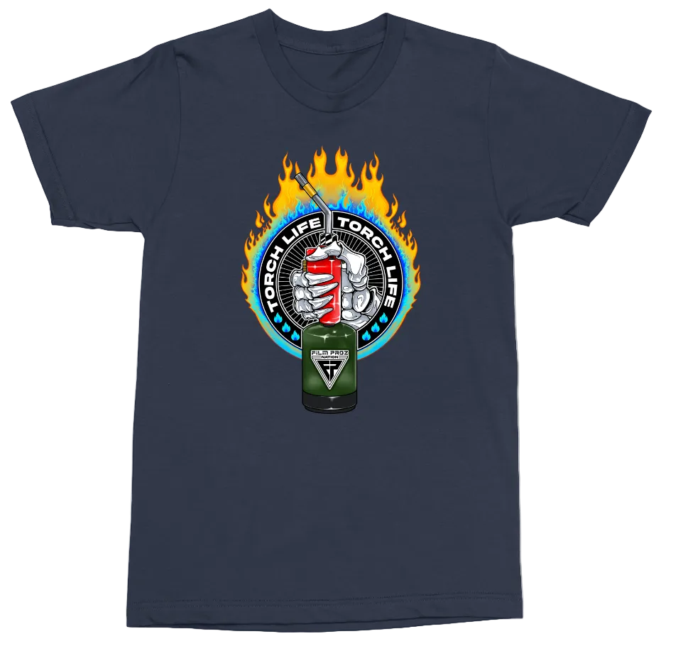 A navy blue crewneck t-shirt featuring a circular graphic on the chest with flames, a hand holding a red and white torch, and a green propane tank in front. The text 'TORCH LIFE TORCH ME' is printed around the circular graphic.
