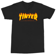 Load image into Gallery viewer, A black short-sleeve crewneck t-shirt featuring a prominent orange and yellow flame-style graphic on the chest that reads 'TINTER' with 'LIFESTYLE' underneath.
