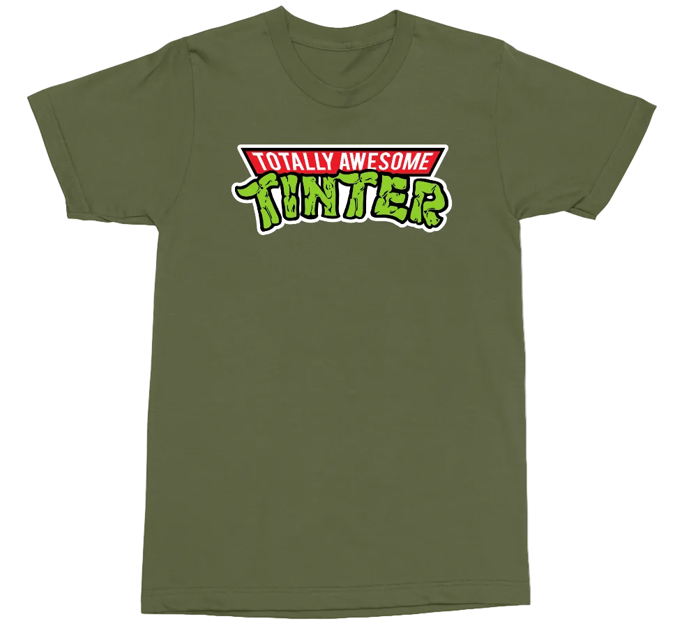 An olive green short-sleeve crewneck t-shirt featuring a 'Totally Awesome Tinker' graphic on the chest, displayed against a solid white background.